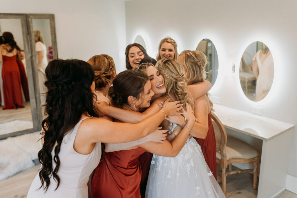 Bride gives big group hug to bridesmaids in the bridal suite at Bella Cavalli in DFW